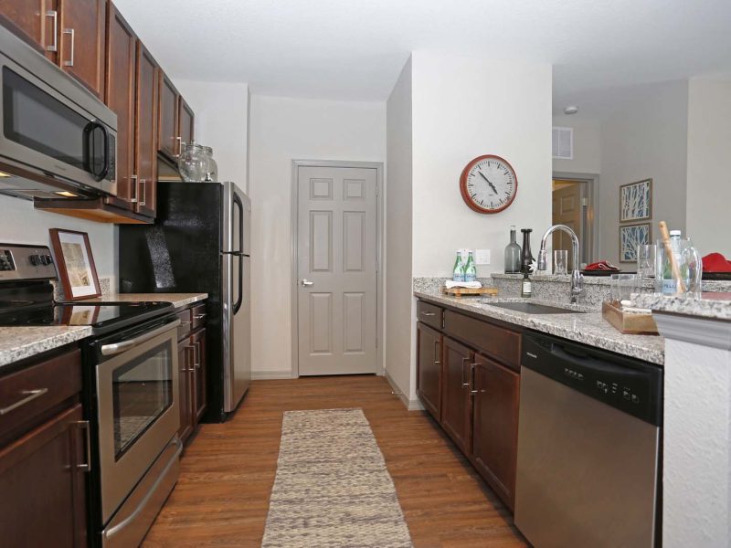 This image shows the Premium Apartment Featuring the gourmet kitchen with a breakfast bar, farmhouse sink, and stainless steel kitchen appliances.