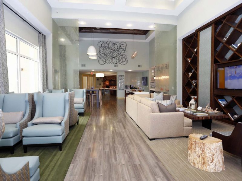 This image shows the clubhouse featuring a spacious area with a comfortable business lounge or sitting area and a flat-screen TV.