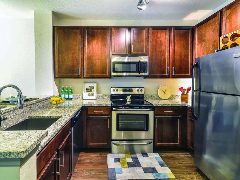 This image shows the Premium Apartment Featuring the gourmet kitchen with a breakfast bar, farmhouse sink, and stainless steel kitchen appliances.