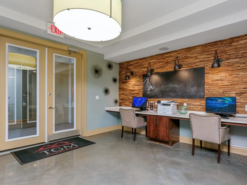 Modern office reception with wooden accents, green walls, and natural lighting.