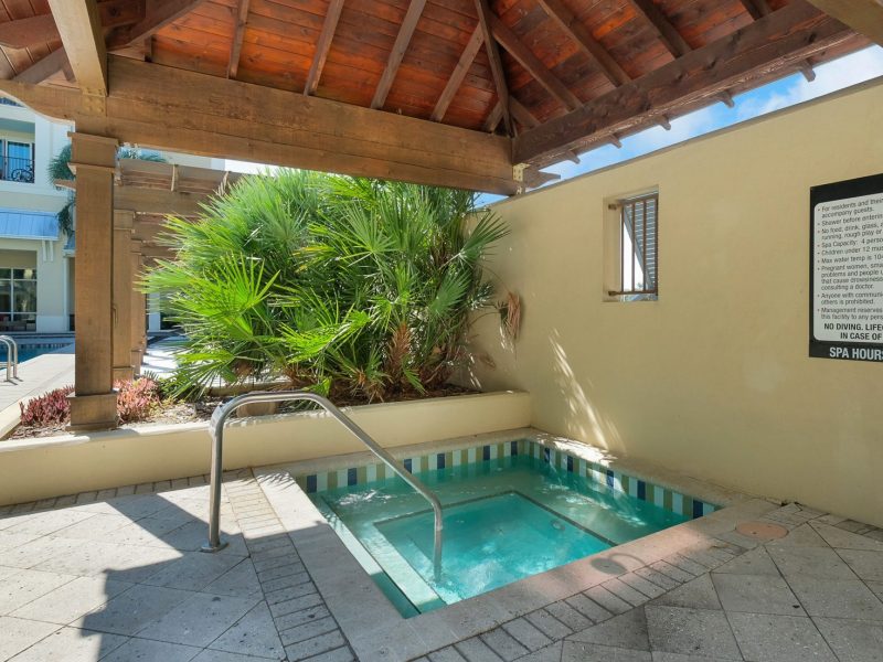 Luxury outdoor spa with wooden pergola, hot tub, and tropical plants for relaxation.